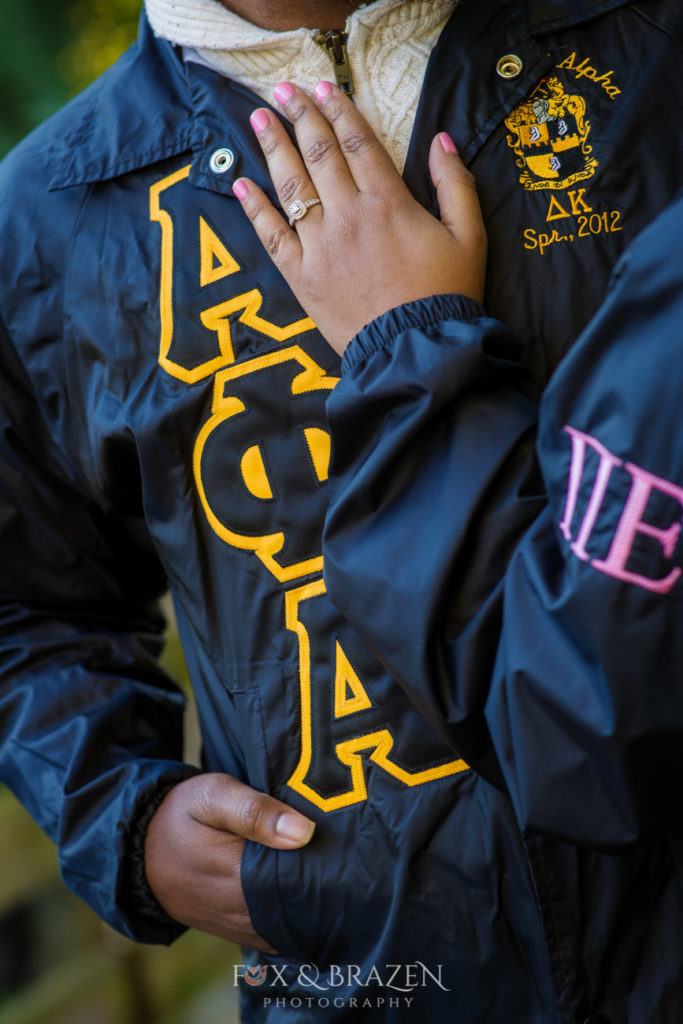 Matching fraternity and Sorority jackets with engaged couple