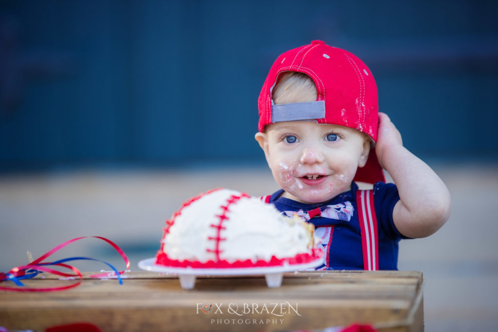toddler wears backwards baseball cap and smiles