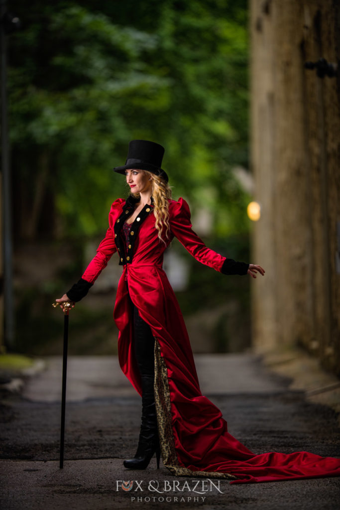 Woman dressed as ringmaster in red coat