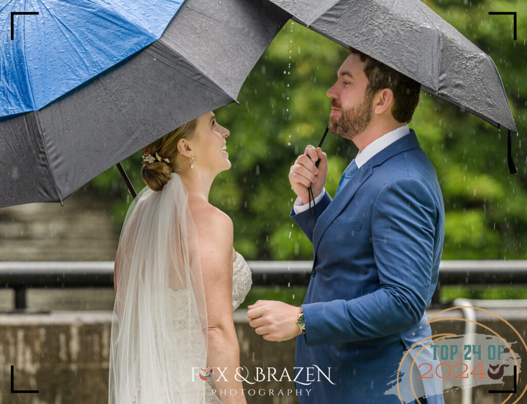 Couple sharing a first look in front of a waterfall in rain.