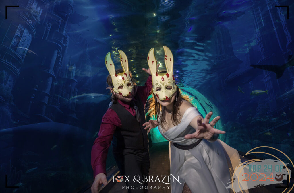 Couple framed under glowing aquarium waters and sharks at Adventure Aquarium