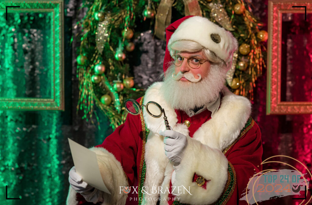 Santa sitting in a festive set designed for the holidays.