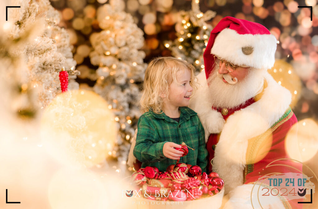 Santa and a child decorating a Christmas tree in 2024 with ornaments.