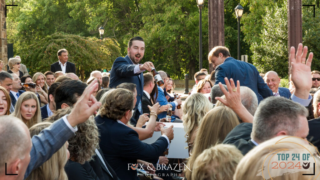 Wedding guests in suits delivering beers at 2024 ceremony.