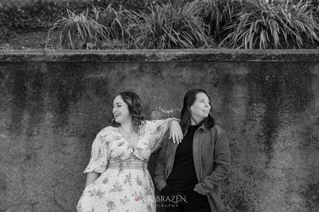 Black-and-white photo of engaged couple looking in opposite directions for their Downtown Phoenixville engagement adventure