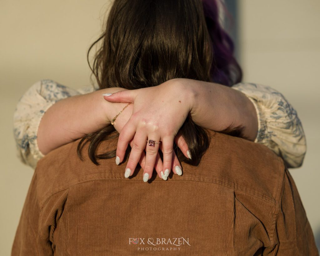 Sunlight highlighting the engagement ring on a bride-to-be's hands.