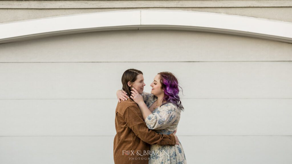 Bride-to-be brushing her partner’s hair aside during an intimate moment.