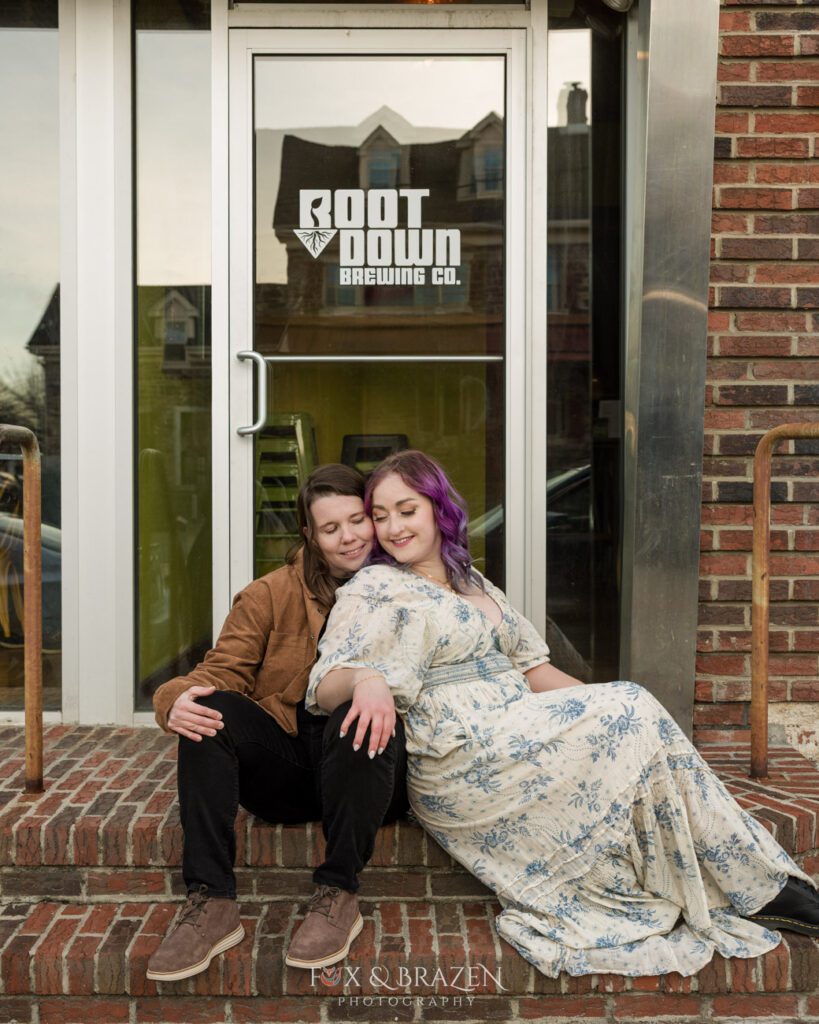 Engaged couple sitting outside Root Down Brewing in Phoenixville.