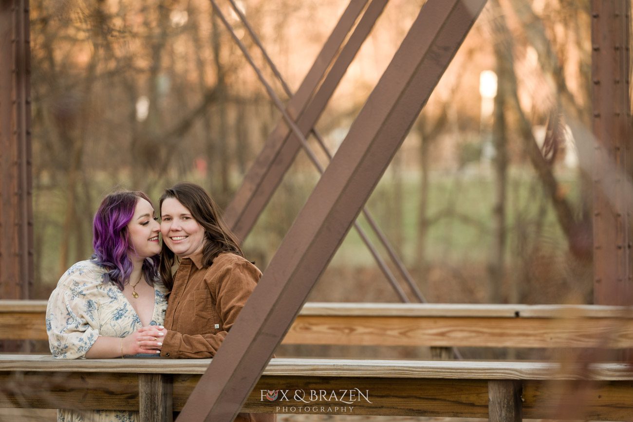 Engaged couple sharing a moment on iconic Phoenixville bridge.