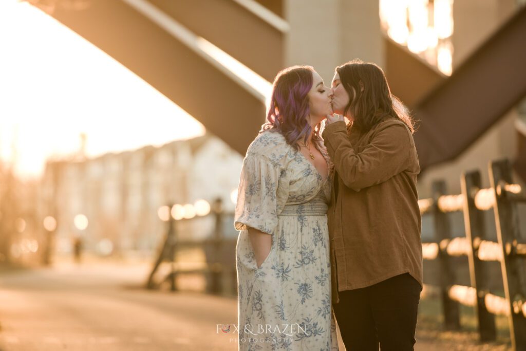Engaged couple sharing a kiss along the Schuylkill River Trail during their photo session.