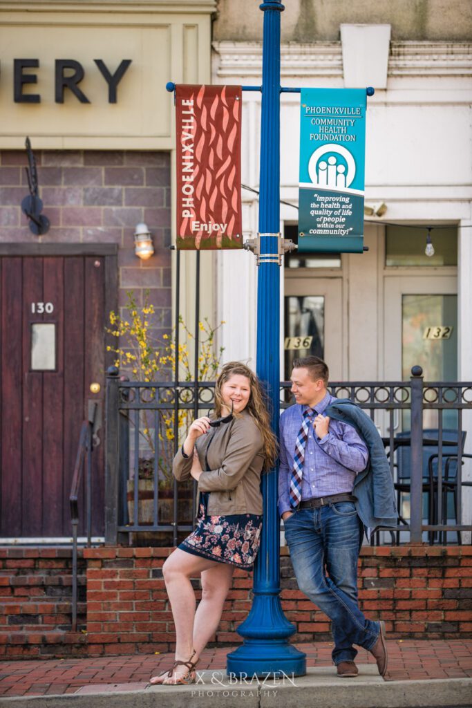 Engaged couple on Bridge Street with lamp post in Phoenixville