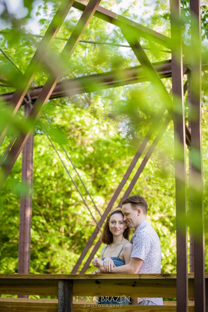 Couple snuggling on iconic Phoenixville iron bridge