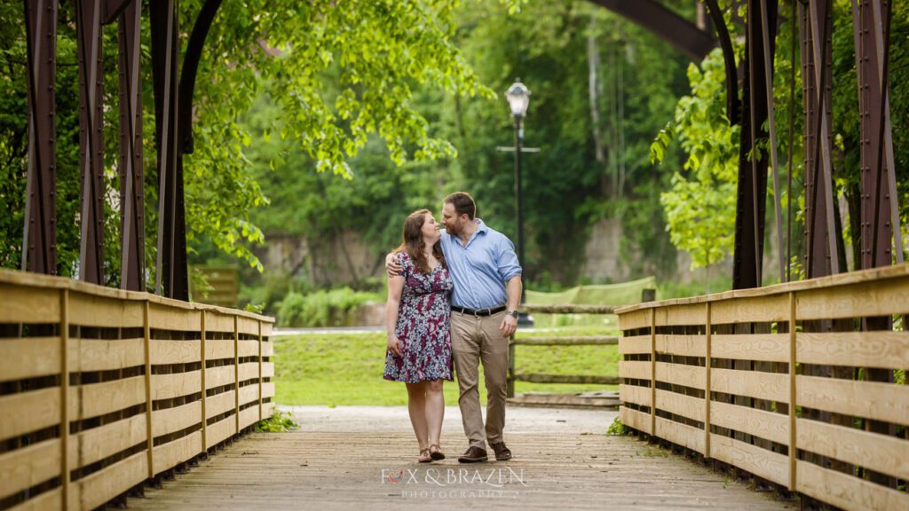 Engaged couple walking together on Phoenixville bridge a great backdrop for Phoenixville engagement sessions