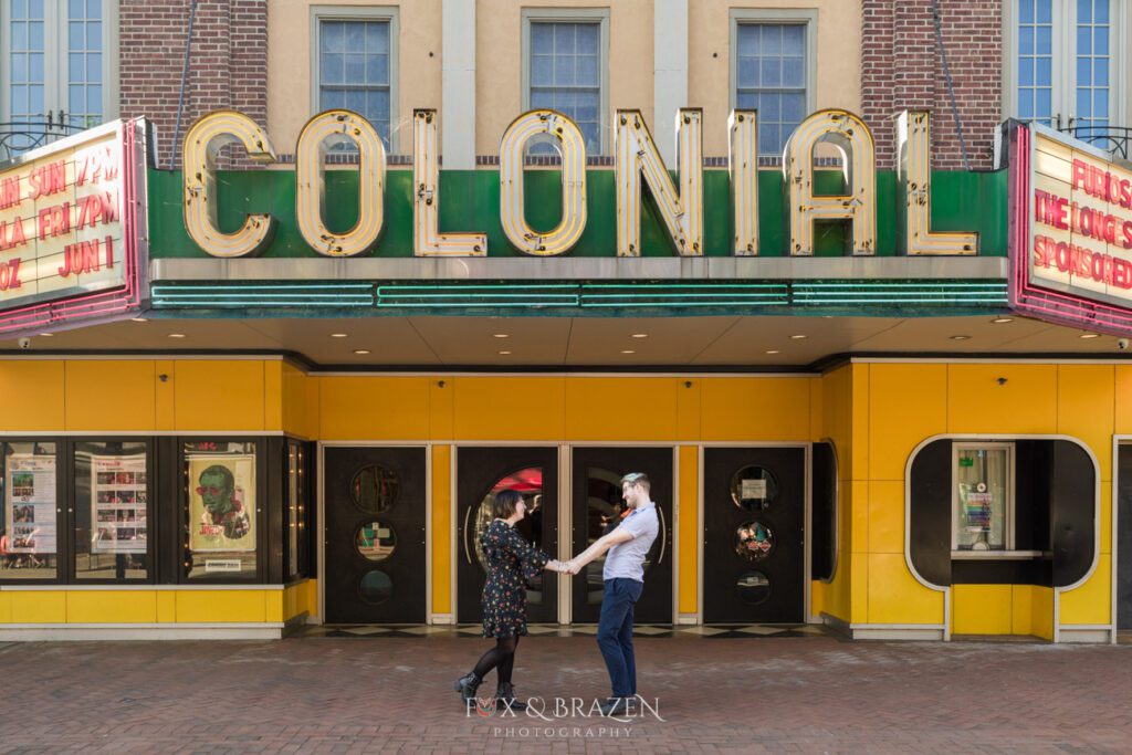Engaged couple strolling near Colonial Theater in Phoenixville an icon for Phoenixville engagement sessions