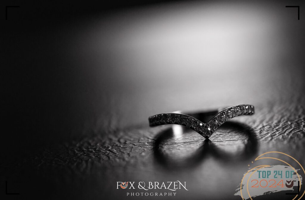 Black-and-white close-up of a wedding band with a heart-shaped shadow.