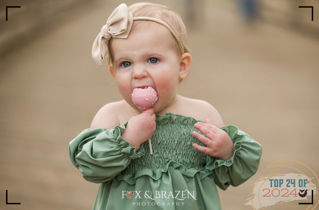 Phoenixville girl wearing green enjoying a pink cake pop.