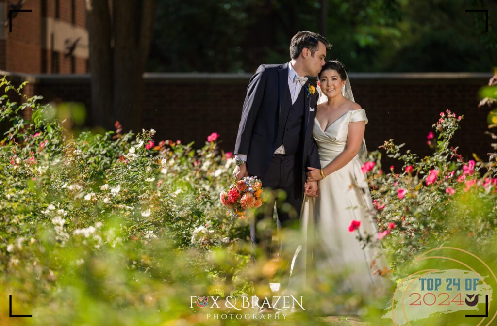 Groom kisses bride’s temple during sunny Old City wedding portraits in 2024.