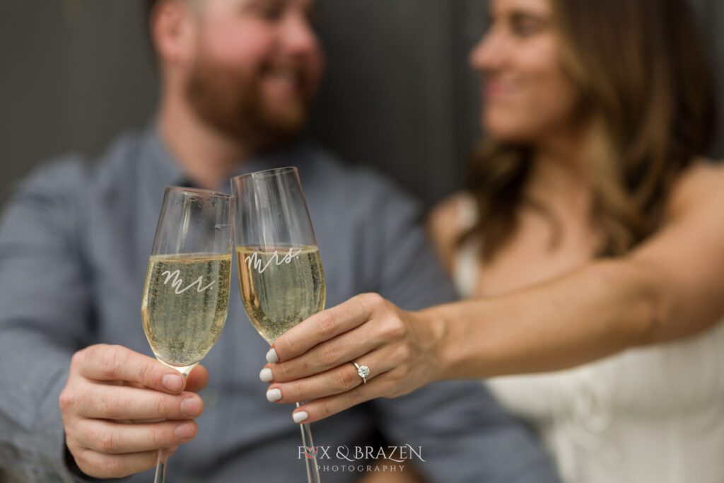 Couple toasting with flutes during their engagement photos at Valley Forge.