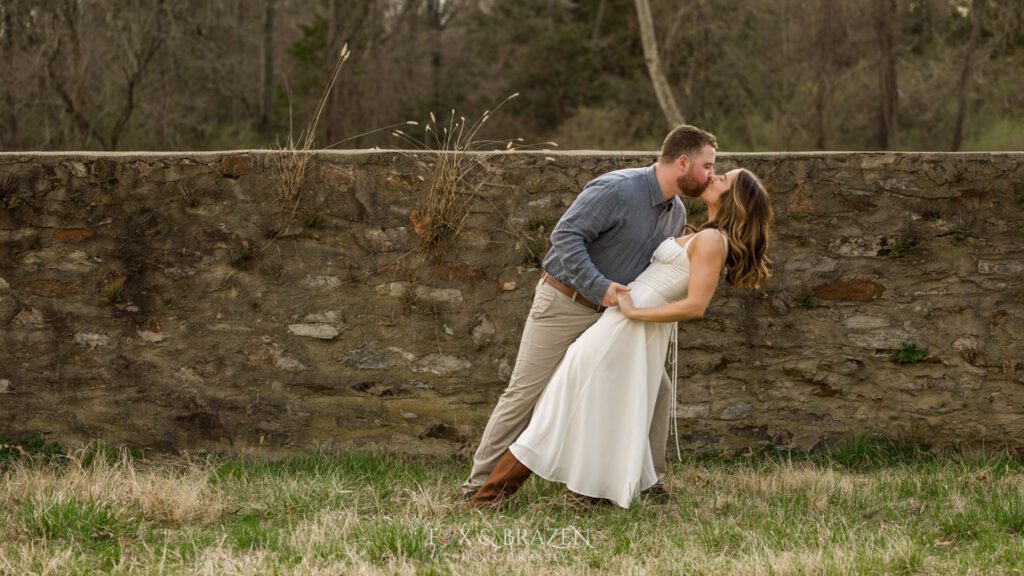Couple sharing a dip in golden light during engagement photos.