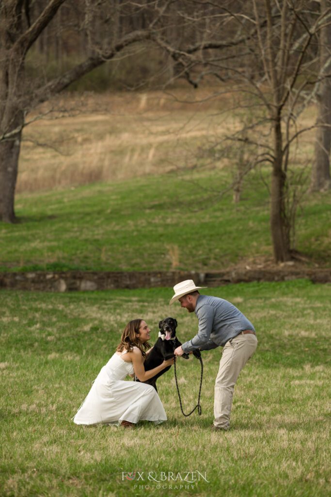 Couple showing affection to their dog during engagement photos.