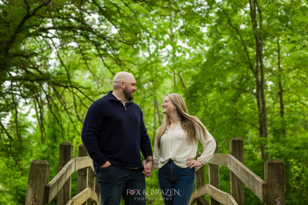 Couple standing on a bridge at Valley Forge, gazing lovingly at each other.