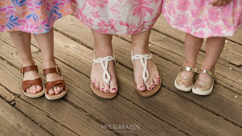 A mother and her daughters feet show casing the matching outfits and cute footwear. Faces are hidden because privacy matters.